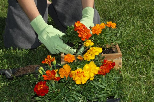 Worker using landscaping equipment with proper protective gear